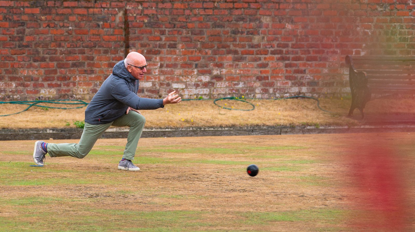 A member delivering a wood on the bowling green.