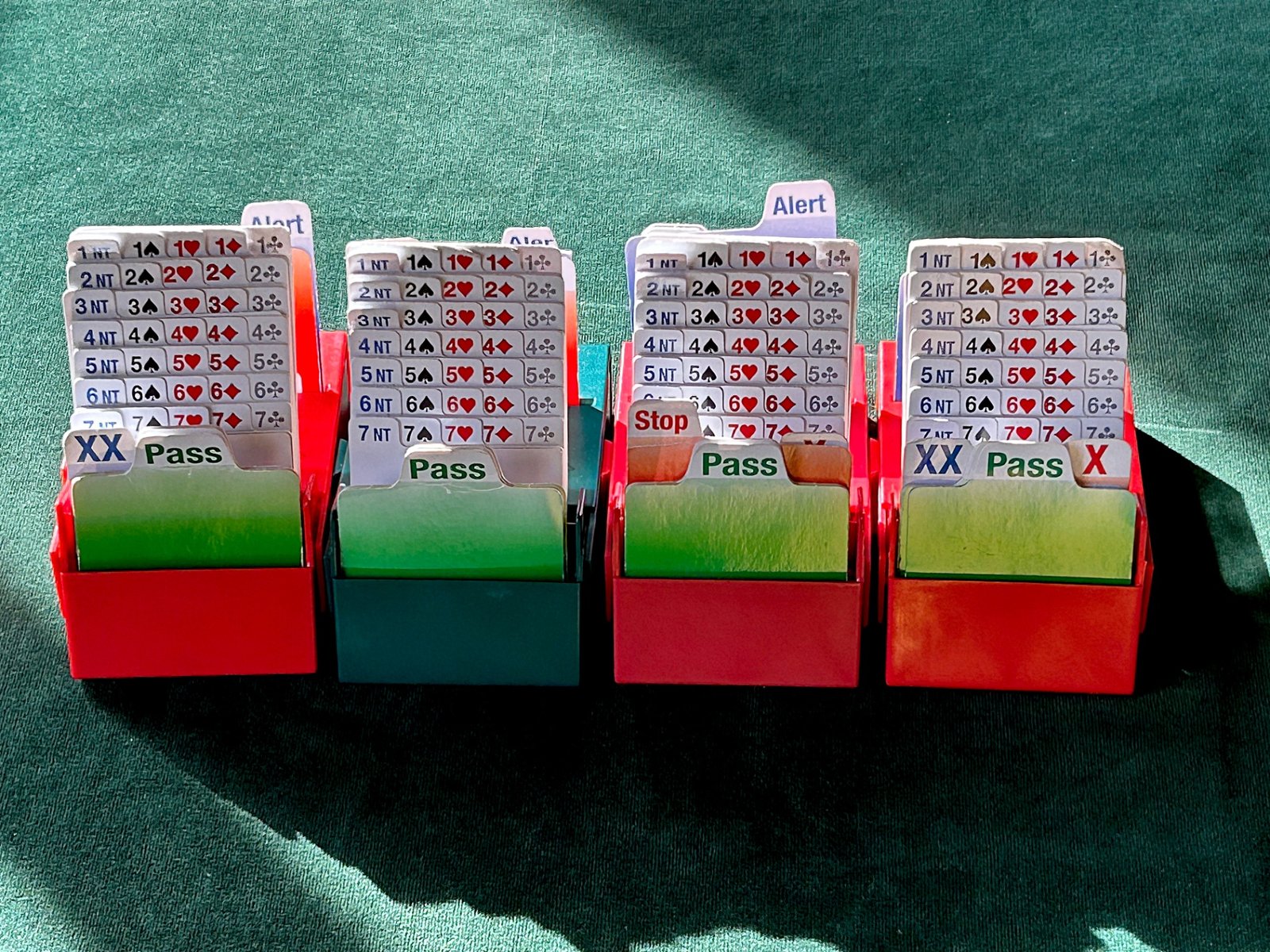 Bridge bidding boxes laid out on green baize