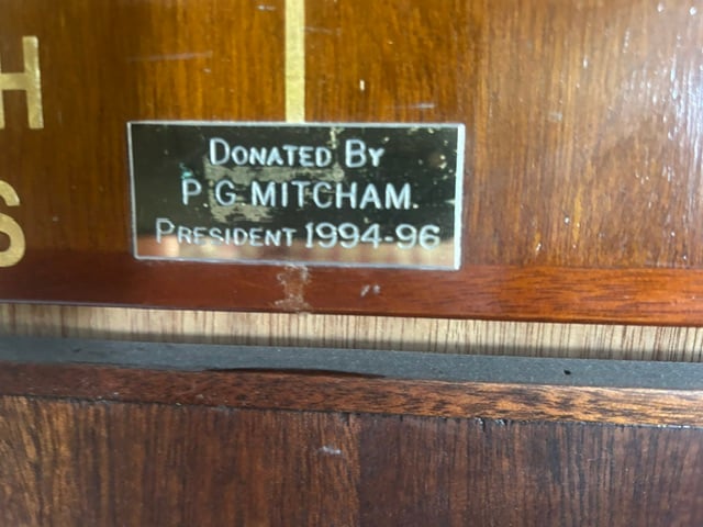 Brass plate on an honours board reading Donated by P. G. Mitcham, President 1994-96